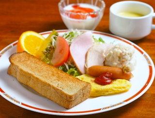 Breakfast plate, omelet sausage, ham potato salad, yogurt etc.