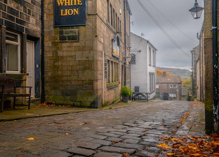 English village cobblestone path autumn leaves